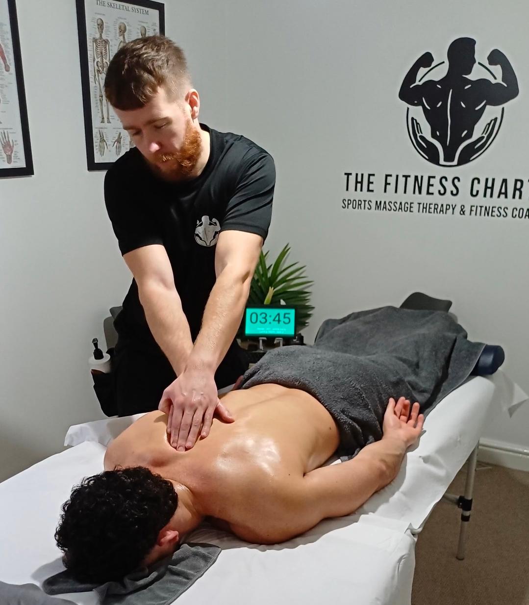 Picture of the sports massaage therapist, Andrew B, at The Fitness Charter performing sports massage on a client's back